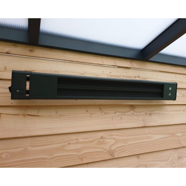 Schwarze Aluminium-Heizung an einer Holzwand montiert, unter einem transparenten Dach