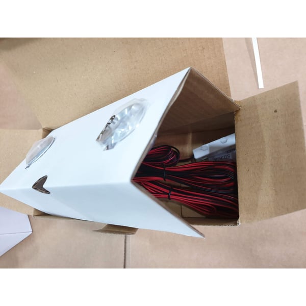 Zwei blanke LED Extra Spots aus Aluminium mit Kabeln in offener Produktverpackung im Karton