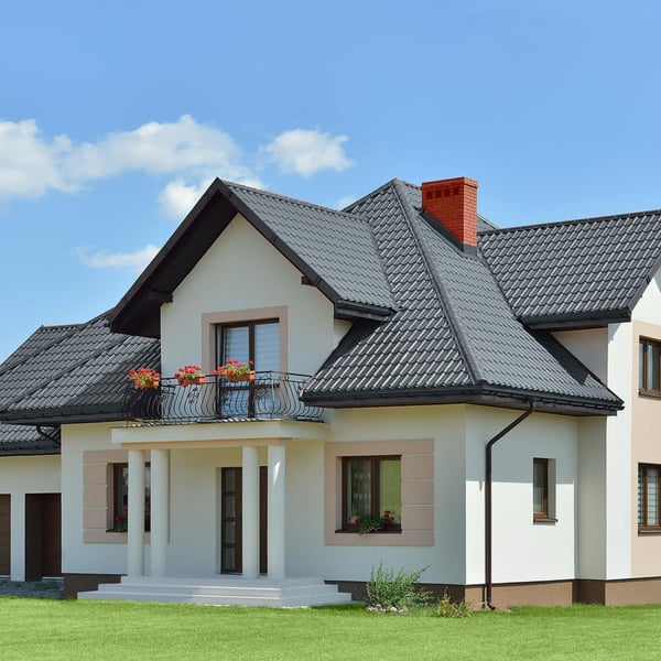Pfannenblech Szafir 350/15 anthrazitgrau auf einem weissen Wohnhaus mit Balkon