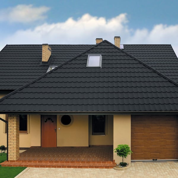 Pfannenblech Szafir 350/15 anthrazitgrau auf einem beigen Wohnhaus mit Gaube und Dachfenster