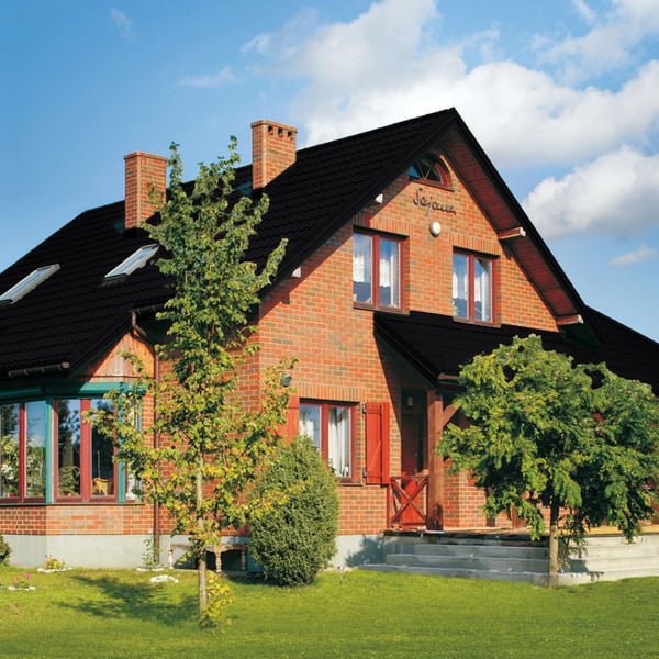 Pfannenblech Szafir 350/15 Tiefschwarz auf einem Ziegelhaus mit Schornsteinen, Verlegung am Dach