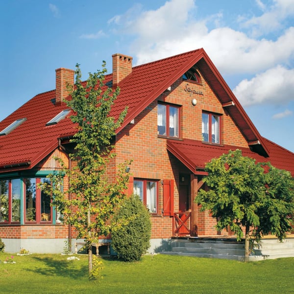 Ziegelhaus mit Dach aus korallenrotem Pfannenblech Szafir 350/15