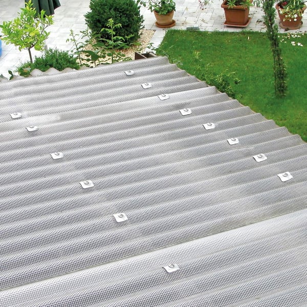 Verlegung der klaren Polycarbonat Wellplatten auf einem Dach mit sichtbaren Abstandshaltern