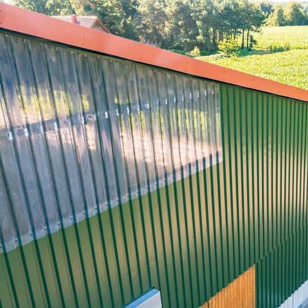PVC Spundwandplatte klarbläulich als Lichtband in einer grünen Trapezblechwand verbaut, Anwendungsbeispiel