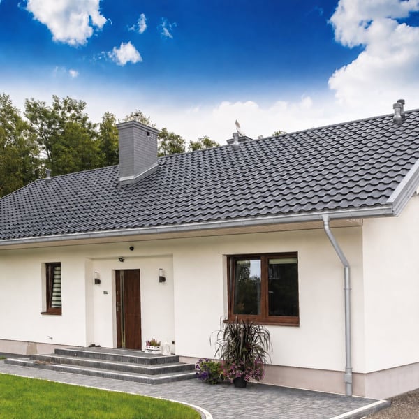 Haus mit Titanzink-Dachrinne und Rinnenablauf, Anwendungsbeispiel mit blauen Himmel