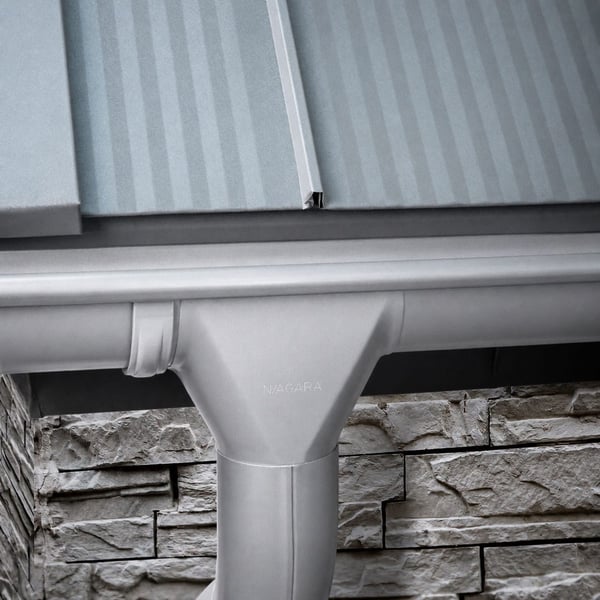 Stahl Dachrinne in Weißaluminium mit Niagara-Logo am Rinnenstutzen, montiert unter einem Dach