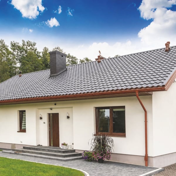 Gesamtes Haus mit kupferbrauner Niagara Stahl Dachrinne und Fallrohren, weisse Fassade, dunkles Dach