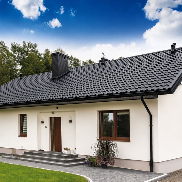 Weisses Haus mit schwarzem Dach und Niagara Stahl Dachrinnen in Tiefschwarz (RAL 9005) komplett montiert