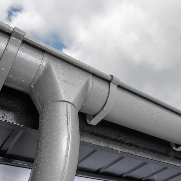 Dachrinne aus Stahl in Graualuminium (RAL 9007) mit Regentropfen und Niagara-Logo, Nahaufnahme