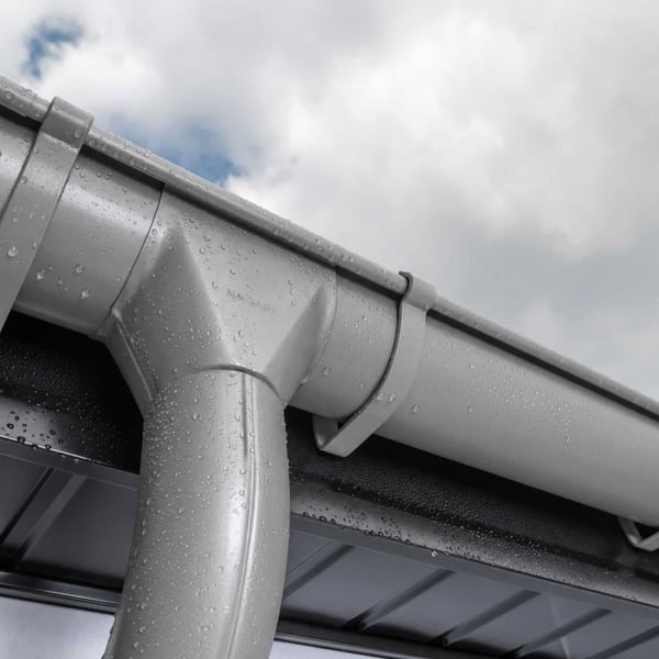 Stahl Dachrinne in Graualuminium (RAL 9007) mit Wassertropfen nach Regen, Detailansicht der Rinne und des Fallrohrs