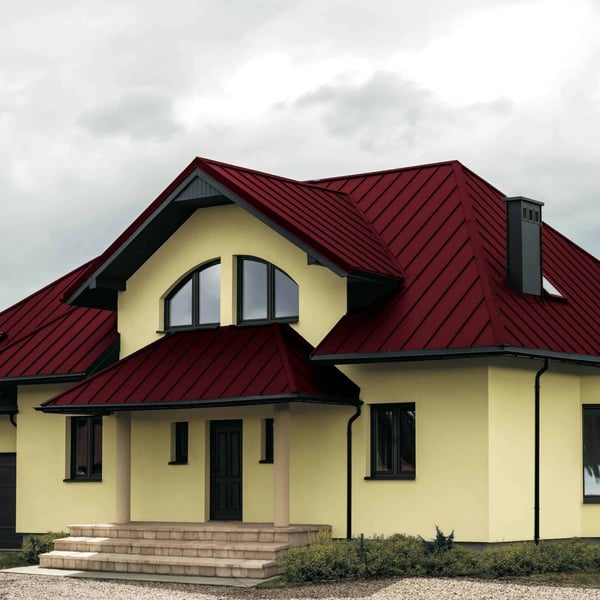 Haus mit Dach aus Stehfalzblech PD-510-S Flach Weinrot RAL 3005, Vorderansicht mit Eingangsbereich