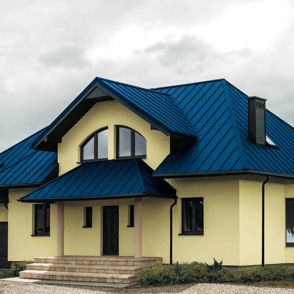 Stehfalzblech PD-510-S Flach Enzianblau auf einem Wohnhaus mit Rundbogenfenstern und Gauben, Verlegung