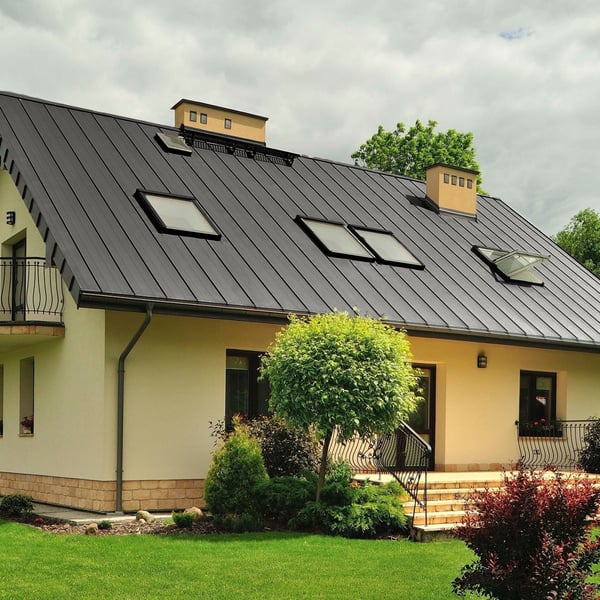 Stehfalzblech PD-510-S Flach Graualuminium auf einem Wohnhaus mit mehreren Dachfenstern