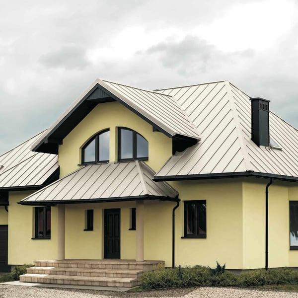 Haus mit reinweißem Stehfalzblech PD-510-S Flach Dach, Gauben und dunklen Fenstern