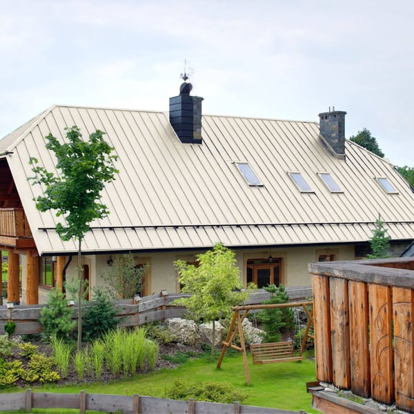 Stehfalzblech PD-510-S Mikro Reinweiß auf einem Landhaus mit Gauben und Schornsteinen