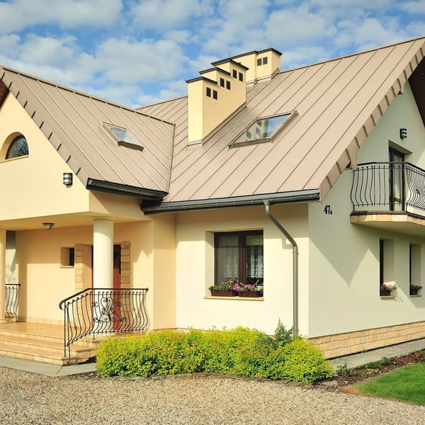 Stehfalzblech PD-510-S Mikro Hellelfenbein RAL 1015 am Dach eines Hauses mit Dachfenstern