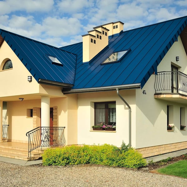 Stehfalzblech PD-510-S Mikro Enzianblau RAL 5010 auf einem Wohnhaus mit Dachfenstern