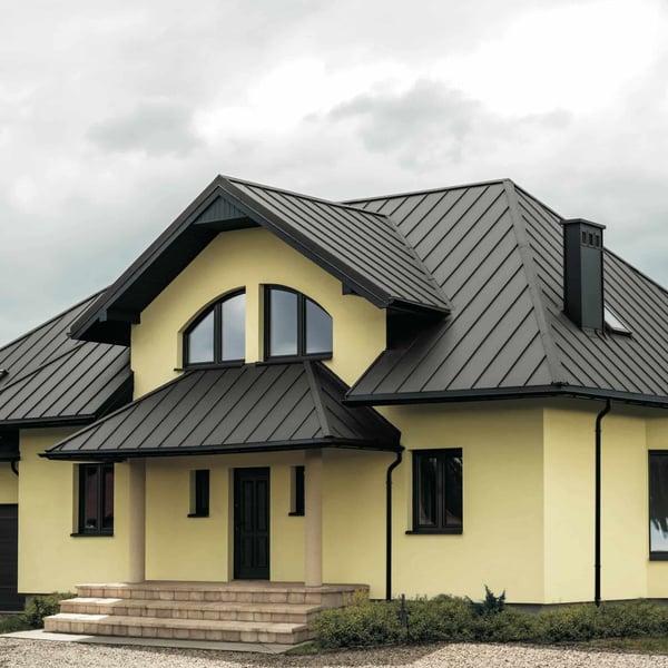 Stehfalzblech PD-510-S Mikro Graualuminium auf einem Wohnhausdach mit Gauben und Schornstein