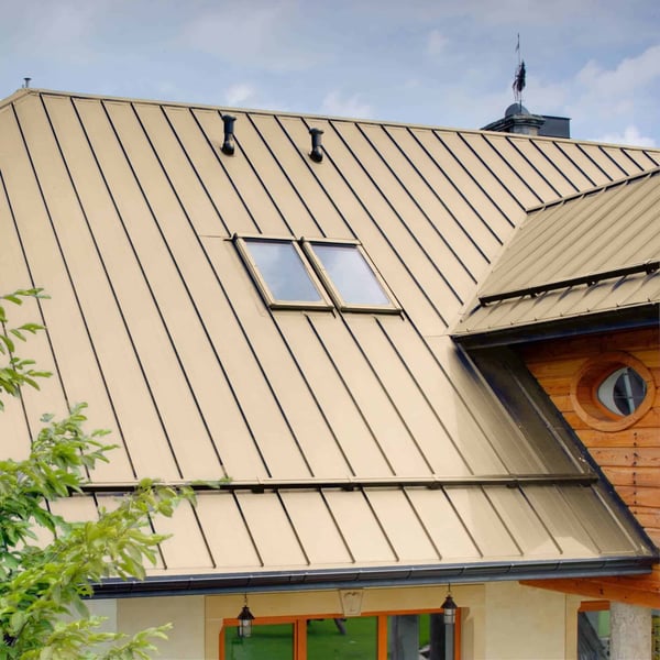Stehfalzblech PD-510-S Hellelfenbein auf einem Dach mit Holzverkleidung und zwei Dachfenstern