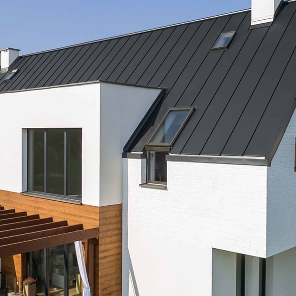 Modernes Haus mit Dach aus Stehfalzblech PD-510-S Graphitgrau, mit Dachfenstern und Holzterrasse