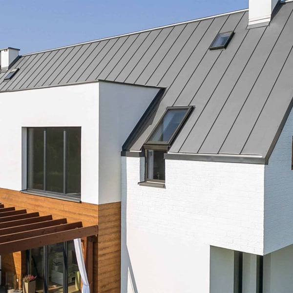 Stehfalzblech PD-510-S Weißaluminium auf einem Hausdach mit Dachfenstern und weissen Waenden