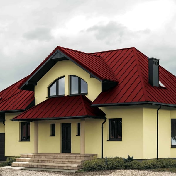 Stehfalzblech PD-510-S Kirschrot auf einem Wohnhaus mit Gauben und Vordach, Verlegung