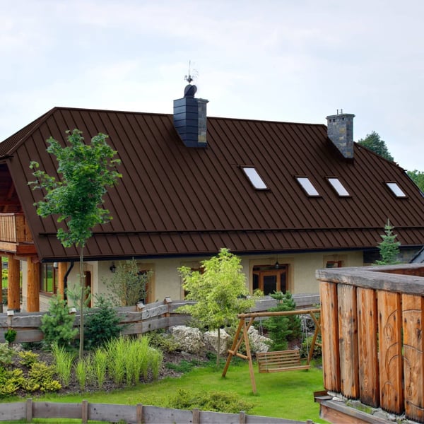 Stehfalzblech PD-510-S schokoladenbraun auf einem Wohnhaus mit vier Dachfenstern