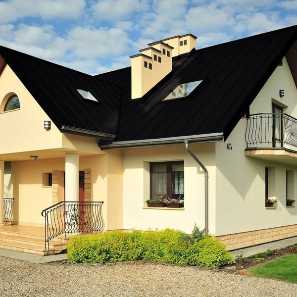 Stehfalzblech PD-510-S Tiefschwarz auf einem Wohnhaus mit Gauben und Dachfenstern