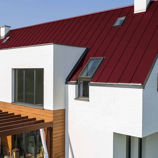 Stehfalzblech PD-510-S weinrot auf einem weissen Haus mit Dachfenstern und Holzterrasse