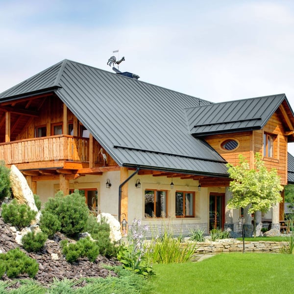 Haus mit Stehfalzblechdach PD-510-S in Fehgrau (RAL 7000), Holzfassade und Gartenlandschaft