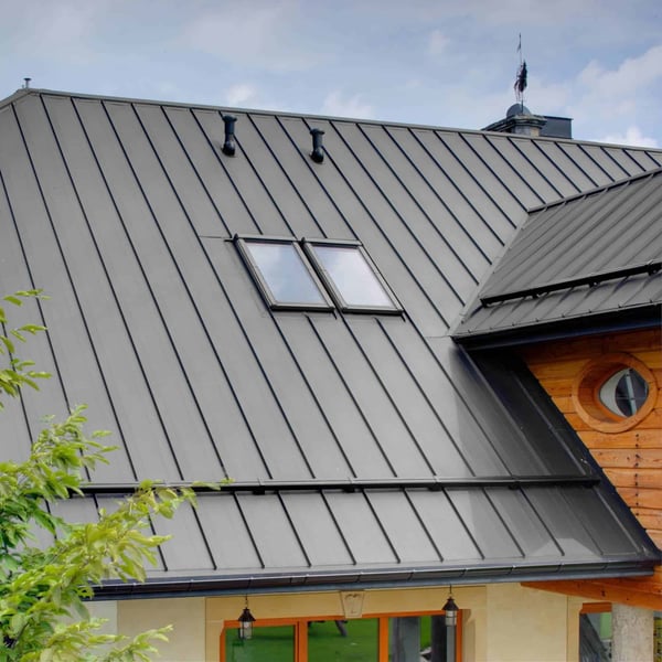 Stehfalzblech PD-510-S Weißaluminium auf einem Dach mit Dachfenstern und Holzverkleidung an der Giebelseite