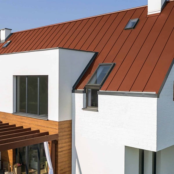 Stehfalzblech PD-510-S Trapez Ziegelrot auf einem Hausdach mit Dachfenstern und Pergola