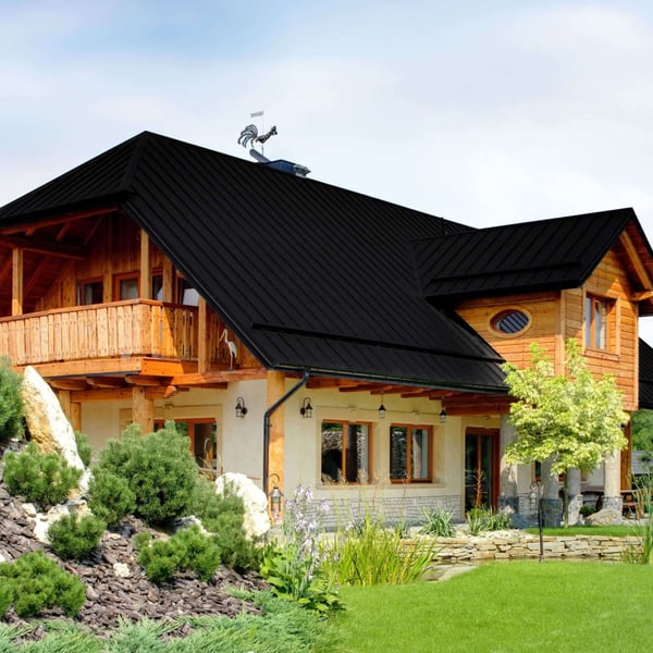 Stehfalzblech PD-510-S Tiefschwarz auf einem Wohnhaus mit Holzelementen und Garten, Verlegung