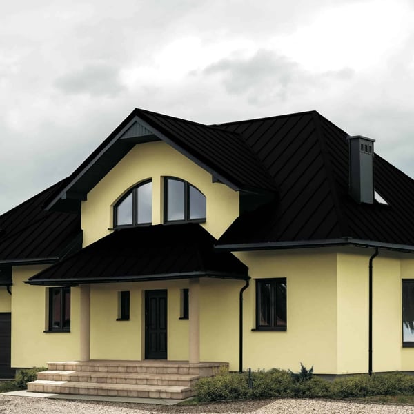Stehfalzblech PD-510-S Tiefschwarz auf einem Wohnhaus mit Gauben und Saeulen, Verlegung