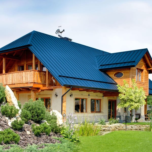 Stehfalzblech PD-510-S Trapez Enzianblau RAL 5010 auf einem Wohnhaus mit Holzfassade
