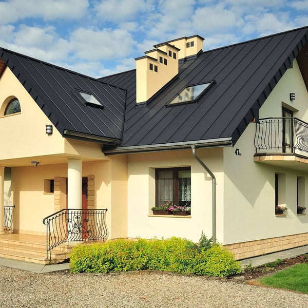 Stehfalzblech PD-510-S Trapez in Graphitgrau auf einem Wohnhaus mit Dachfenstern