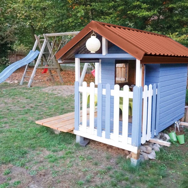 Trapezblech 20/1100 kupferbraun auf dem Dach eines blauen Kinderspielhauses mit Rutsche