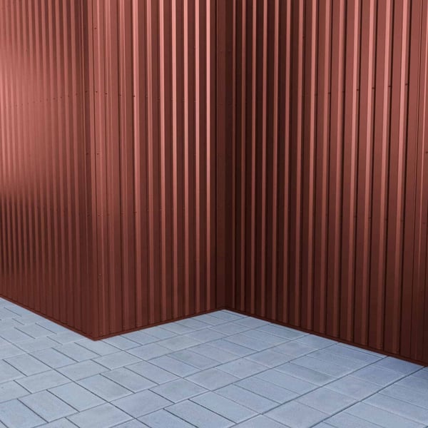 Trapezblech 20/1100 Rotbraun als Eckverkleidung einer Wand mit Pflastersteinen