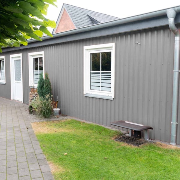 Garagenwand aus Trapezblech 20/1100 Wand in Grau, vertikal verlegt, mit Fenstern und Dachrinne