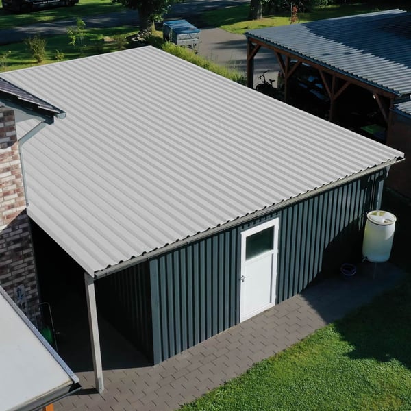 Trapezblech 35/207, Grauweiß, auf dem Dach einer Garage mit dunkelgrauer Wandverkleidung