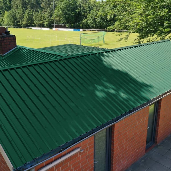 Trapezblech 35/207 Dach Moosgrün auf einem Gebäude neben einem Sportplatz