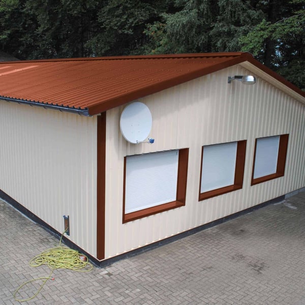 Trapezblech 35/207 in Kupferbraun auf dem Dach einer Lagerhalle mit beiger Fassade