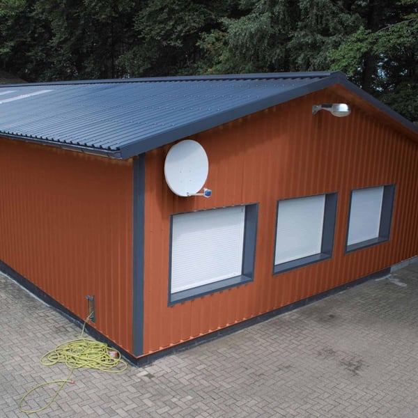 Halle mit Wandverkleidung aus kupferbraunem Trapezblech 35/207 und dunklem Dach