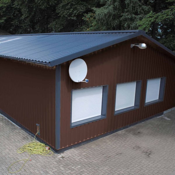 Gebäude mit schokoladenbraunem Trapezblech 35/207 an der Fassade und dunklem Dachblech