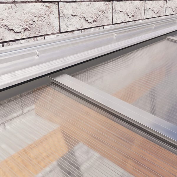 Wandanschlussprofil aus blankem Aluminium auf einer Mauer, ueber Lichtplatten montiert