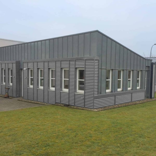 Wellblech 18/1064 in Weißaluminium als Fassadenverkleidung an einem Buero- oder Lagergebaeude