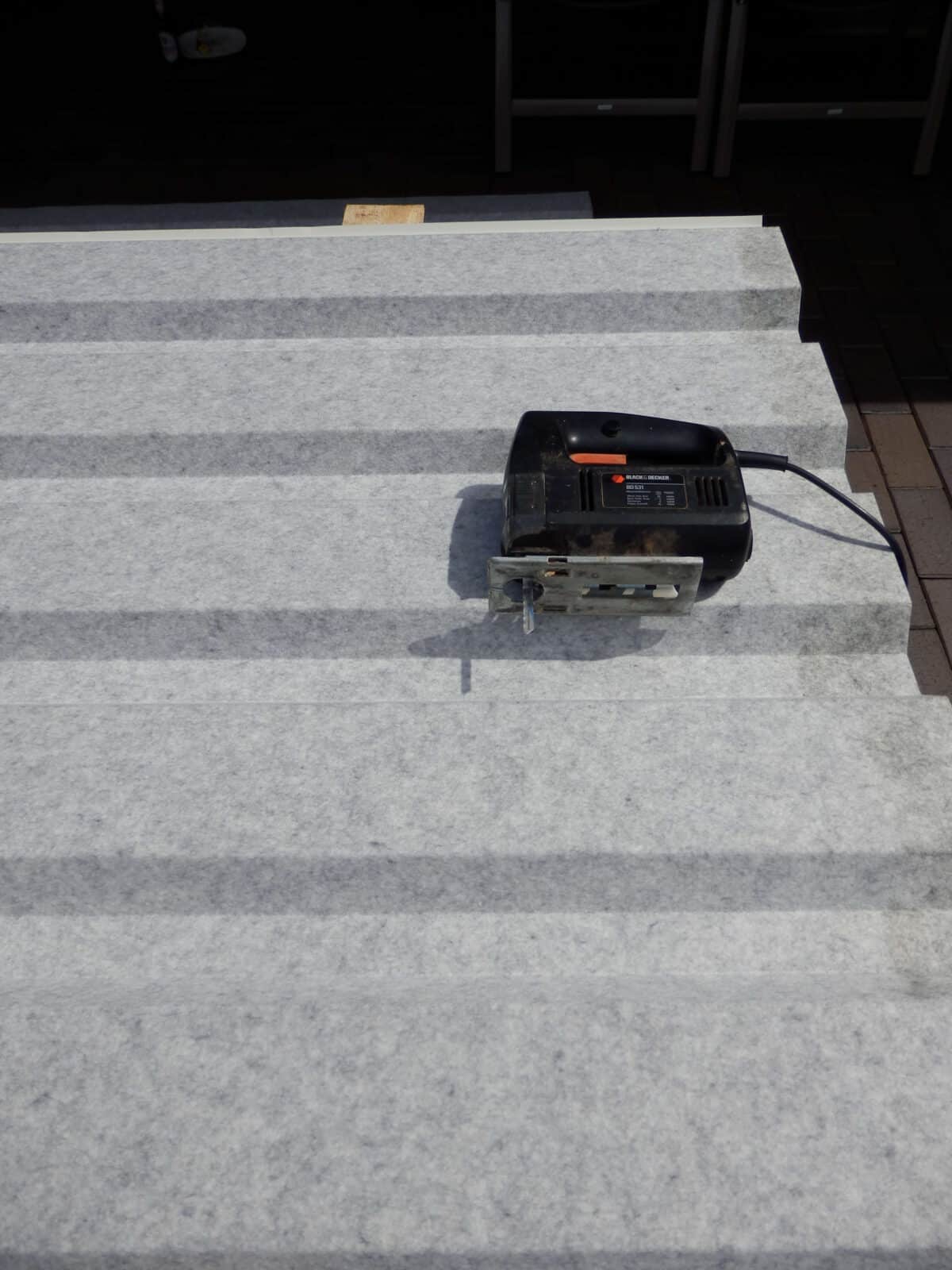 Gezeigt wird eine Stichsäge auf einem Trapezblech.