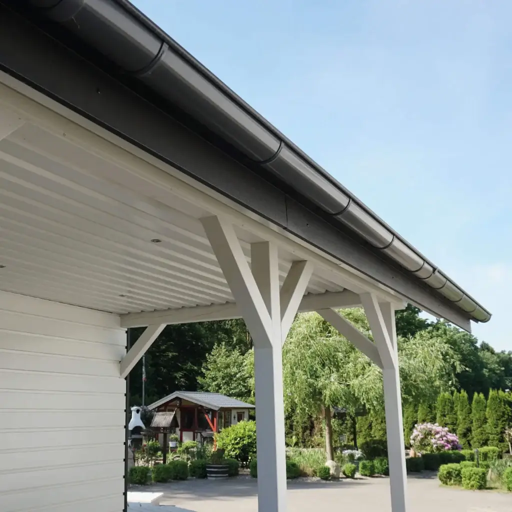 Dachrinne an einem Carport mit Wellblechdach und weißen Stützbalken.