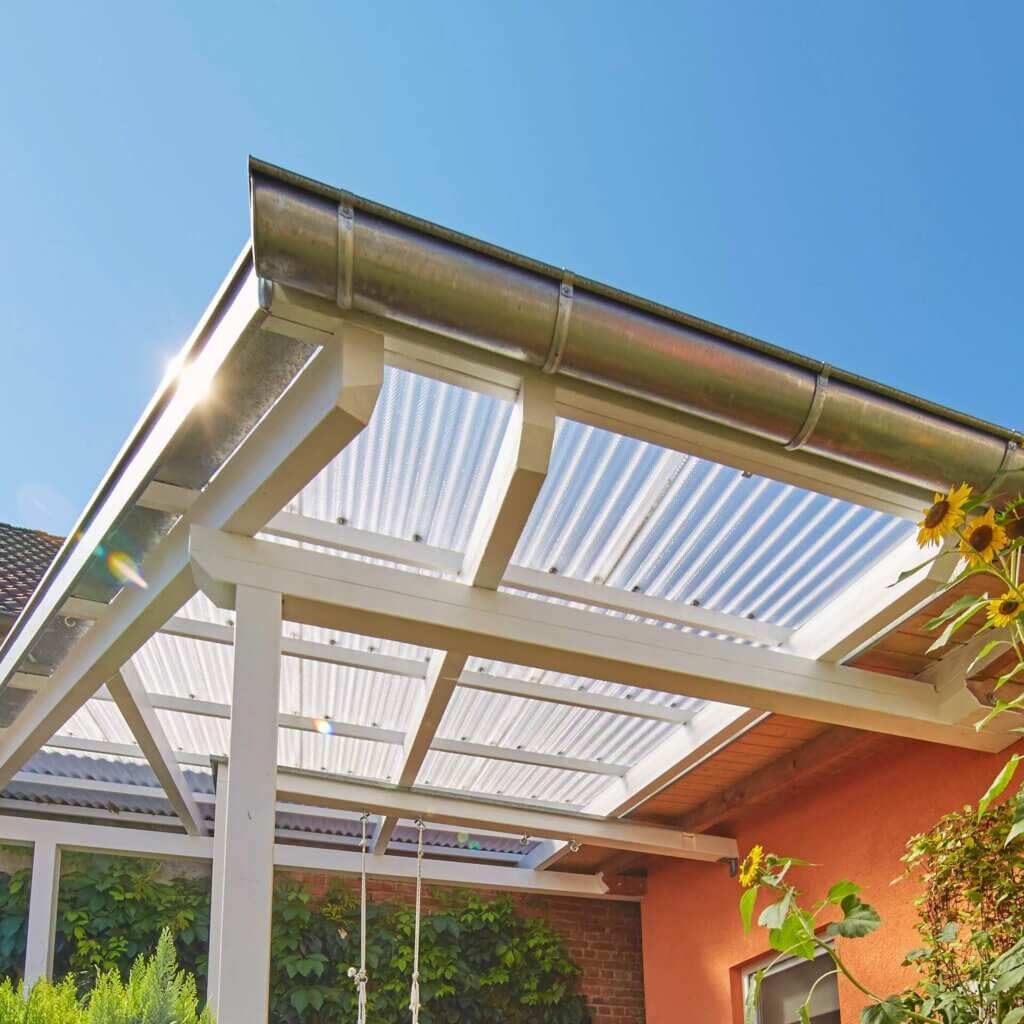 Terrassenüberdachung aus Wellplatten mit einer montierten Dachrinne.
