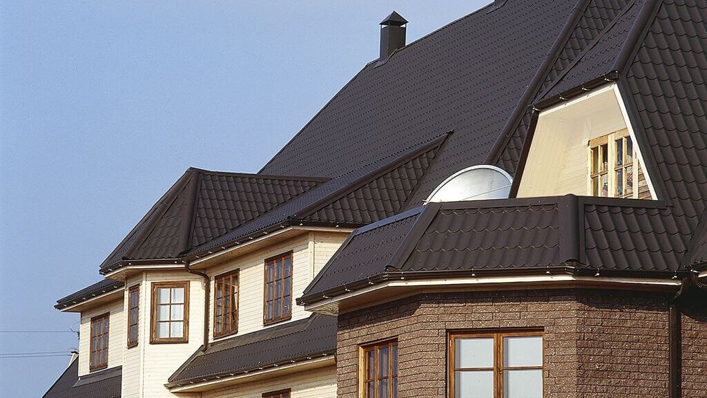 Modernes Wohnhaus mit schwarzem Pfannenblech-Dach – langlebig, witterungsbeständig und optisch ansprechend im klassischen Ziegeldesign.